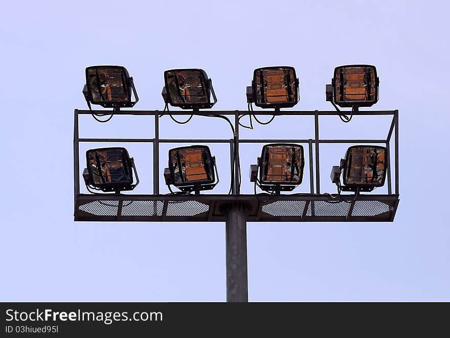 Stadium lights opposite blue sky as background