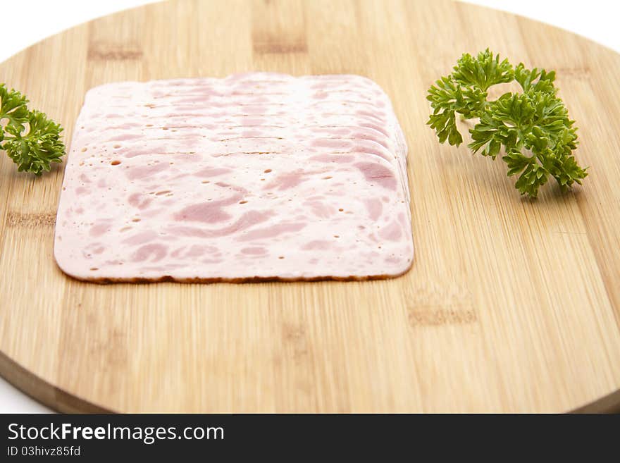 Ham sausage with parsley onto wood plates