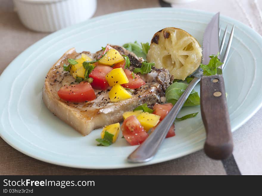 Southern-style pork chop with mango and tomatoes