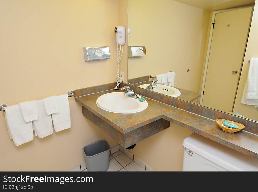 Wash basin area of toilet with basic amenities and towels. Wash basin area of toilet with basic amenities and towels.