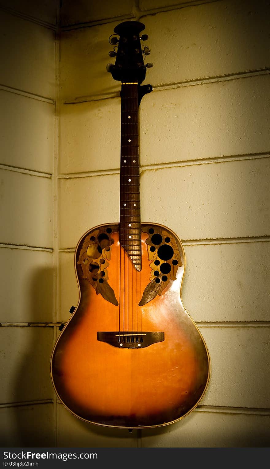 Old acoustic guitar hanging on the old wall. Old acoustic guitar hanging on the old wall