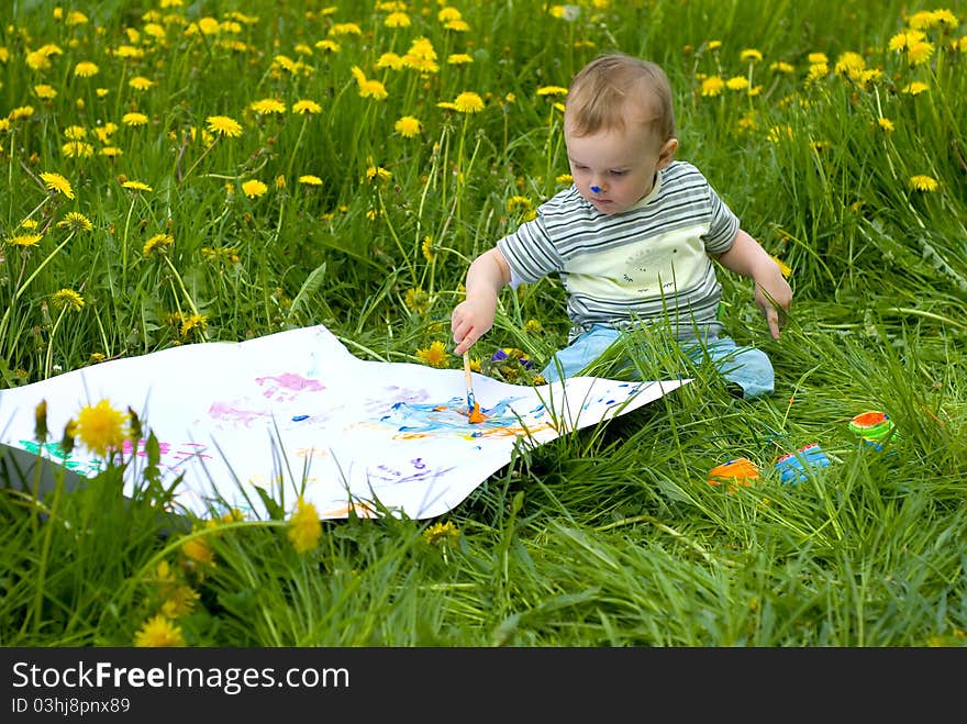 Child painting with paints on the meadow. Child painting with paints on the meadow