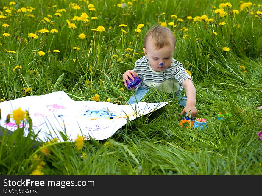 Child painting with paints on the meadow. Child painting with paints on the meadow