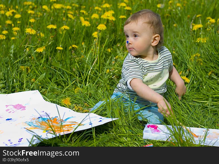 Child painting with paints on the meadow. Child painting with paints on the meadow