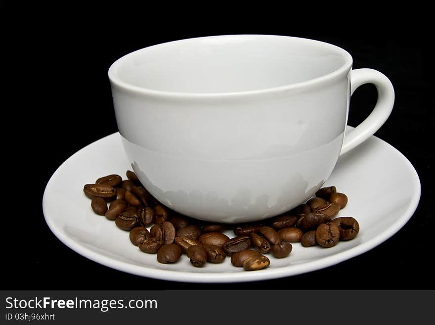 Coffee cup and  beans on black