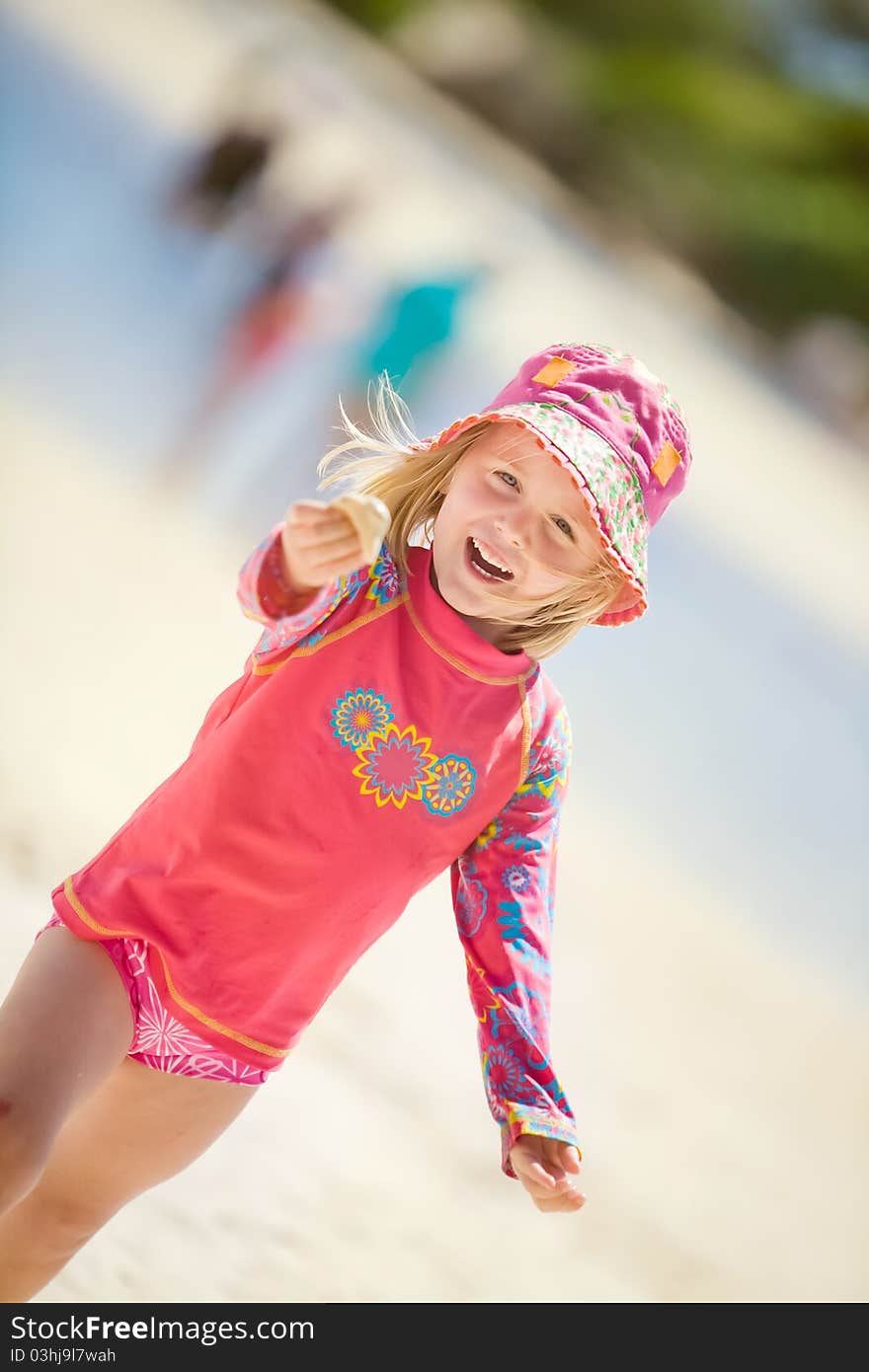 A happy young girl at the beach showing off her shell. A happy young girl at the beach showing off her shell