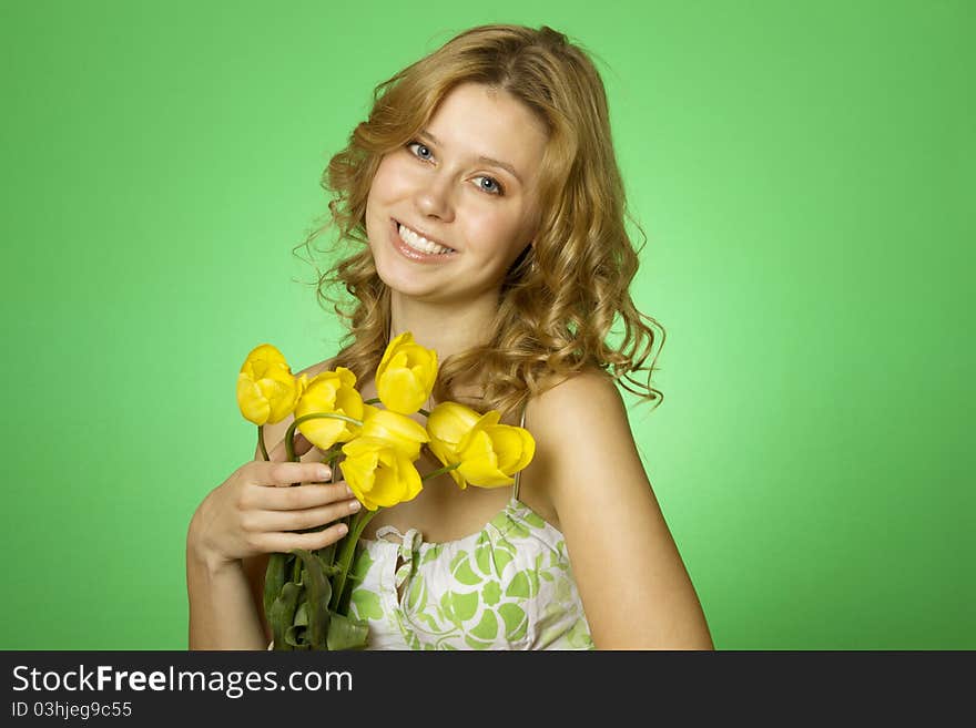 HappyClose up on a green background Happy young woman hugging a yellow tulip. Young Woman Hugging Flower. HappyClose up on a green background Happy young woman hugging a yellow tulip. Young Woman Hugging Flower