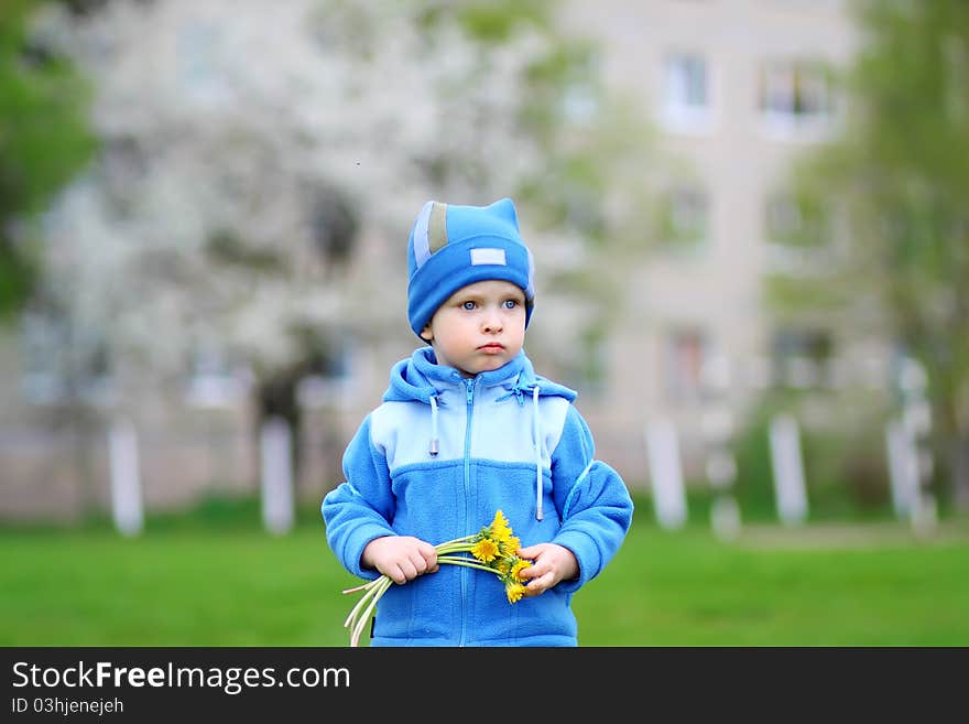 A little boy waiting for his mother with a bouquet of flowers. A little boy waiting for his mother with a bouquet of flowers