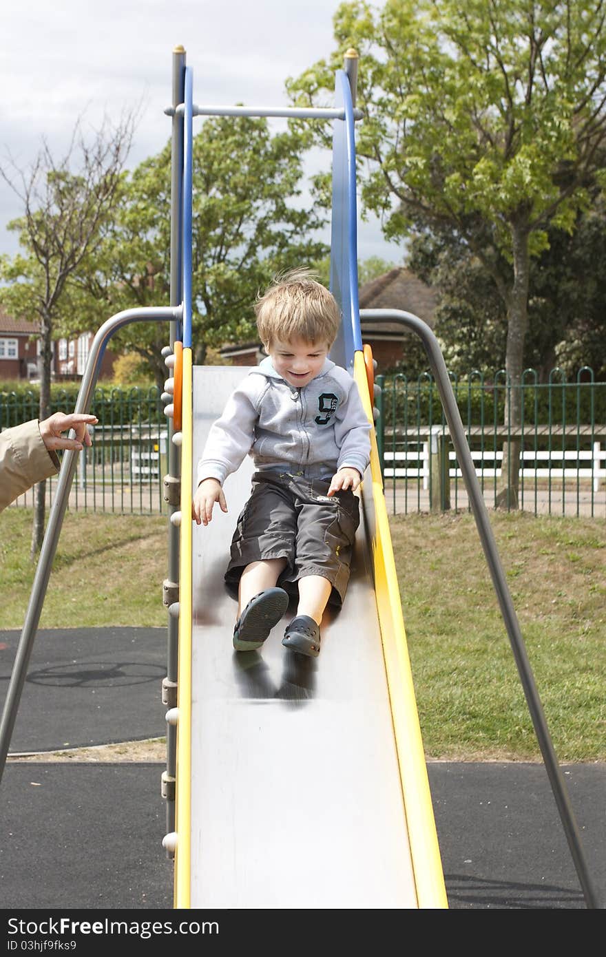 Little boy sliding down a slide