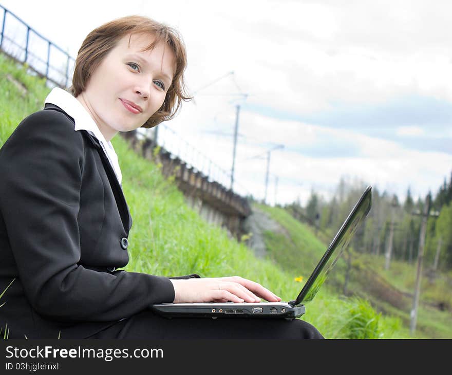 Business woman with laptop in nature.