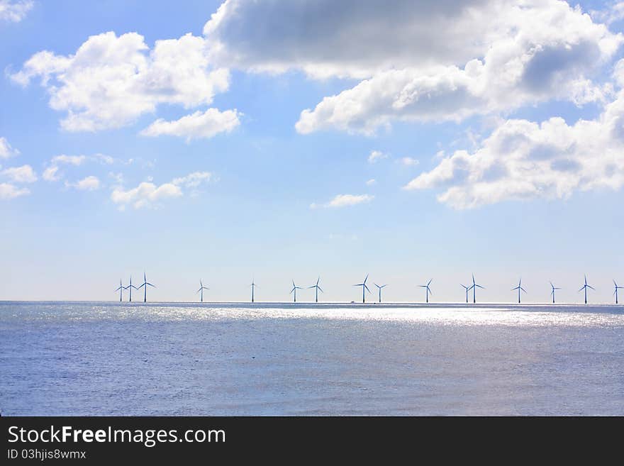 Row of wind turbines out at sea on a summers day. Row of wind turbines out at sea on a summers day