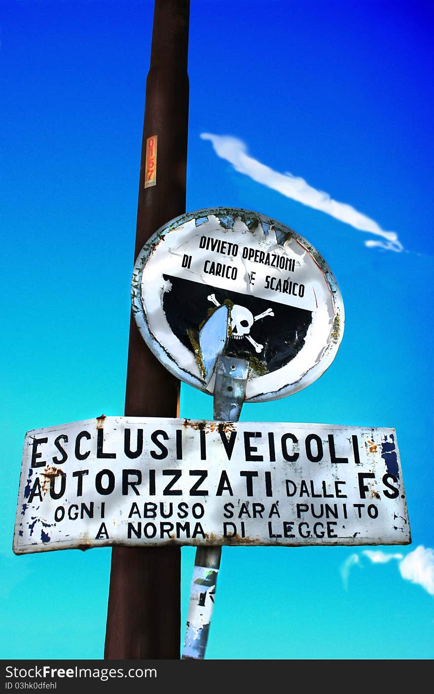 Danger signs with a train station on the background