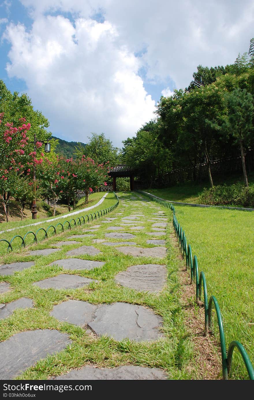 Path in a park leading toward a gate.