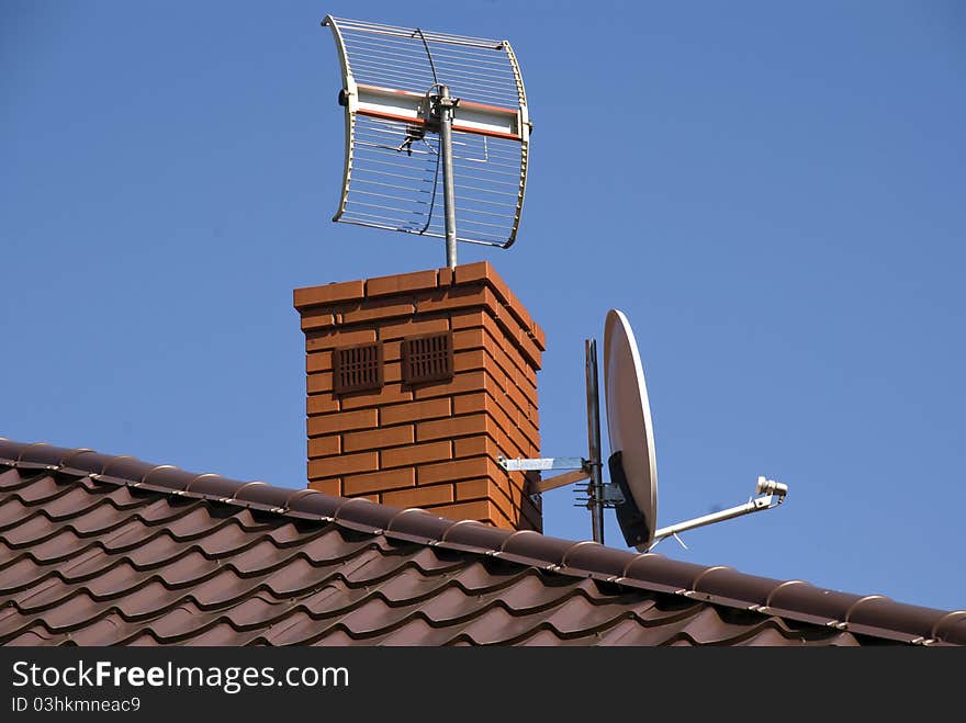 White satellite dish on brown roof. White satellite dish on brown roof