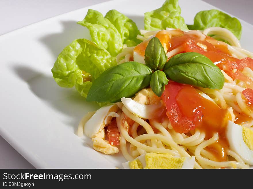 Pasta with tomato sauce, egg, tomato and basil.