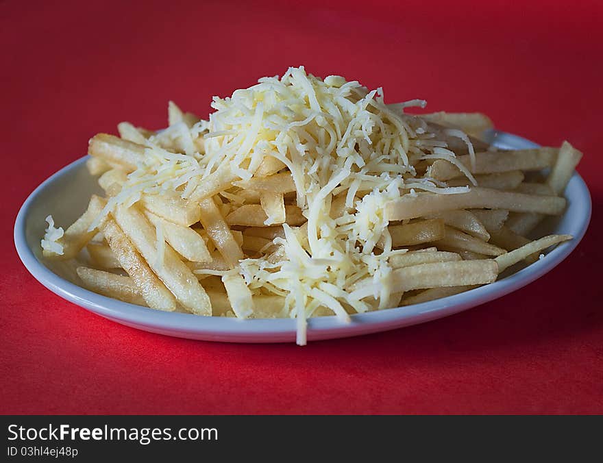 Crunchy french fries with chese on a white plate. Crunchy french fries with chese on a white plate