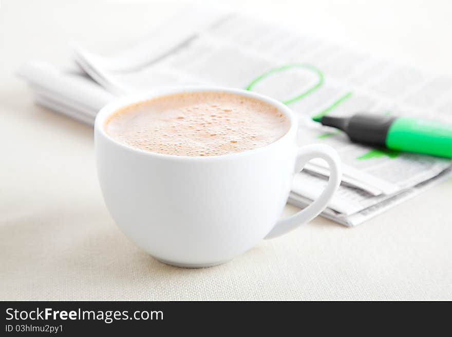 Morning coffee with newspaper on the tablecloth