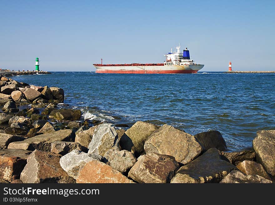 A cargo ship passes by the lighthouses of Warnemuende.