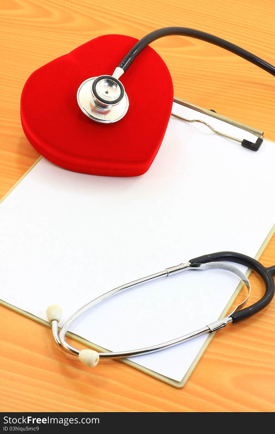 Stethoscope on red heart with paper note. Stethoscope on red heart with paper note