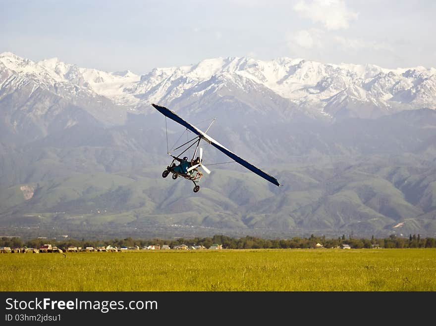 Powered hang glider mountains in the background.