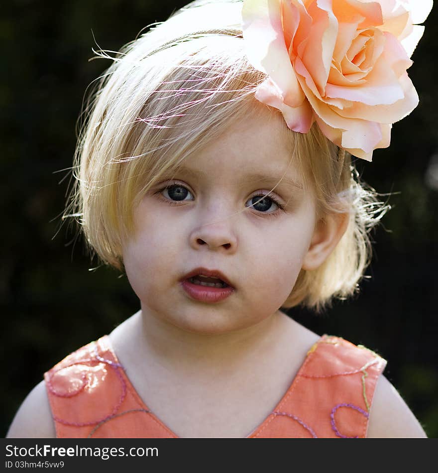 A portrait of a little girl with a flower on her head