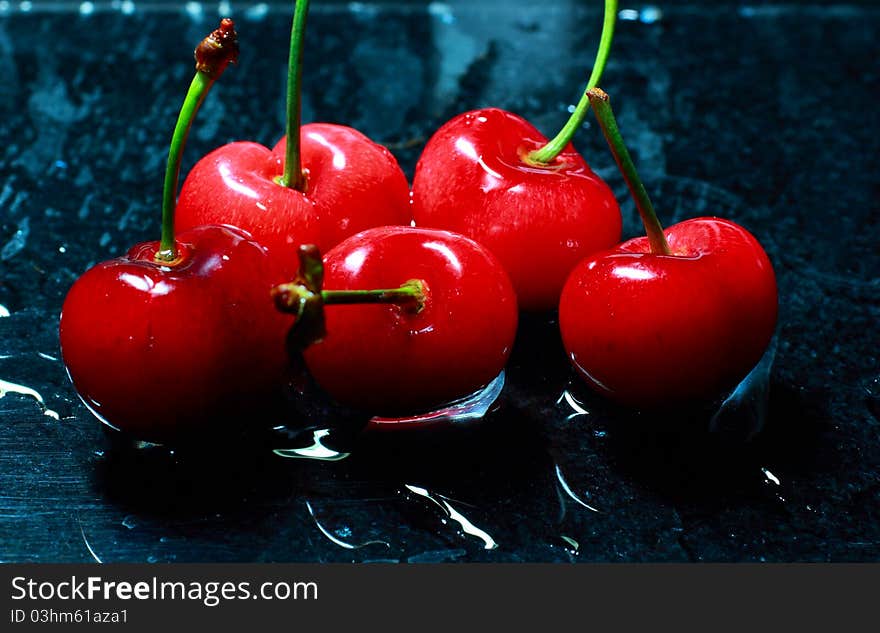 Red cherry on black background.