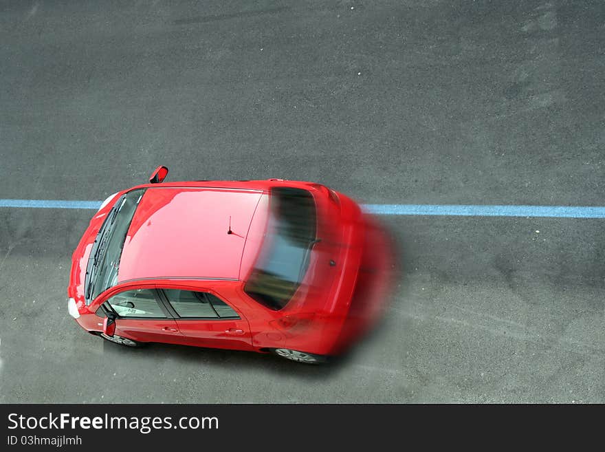 A red car moving on the road view from high