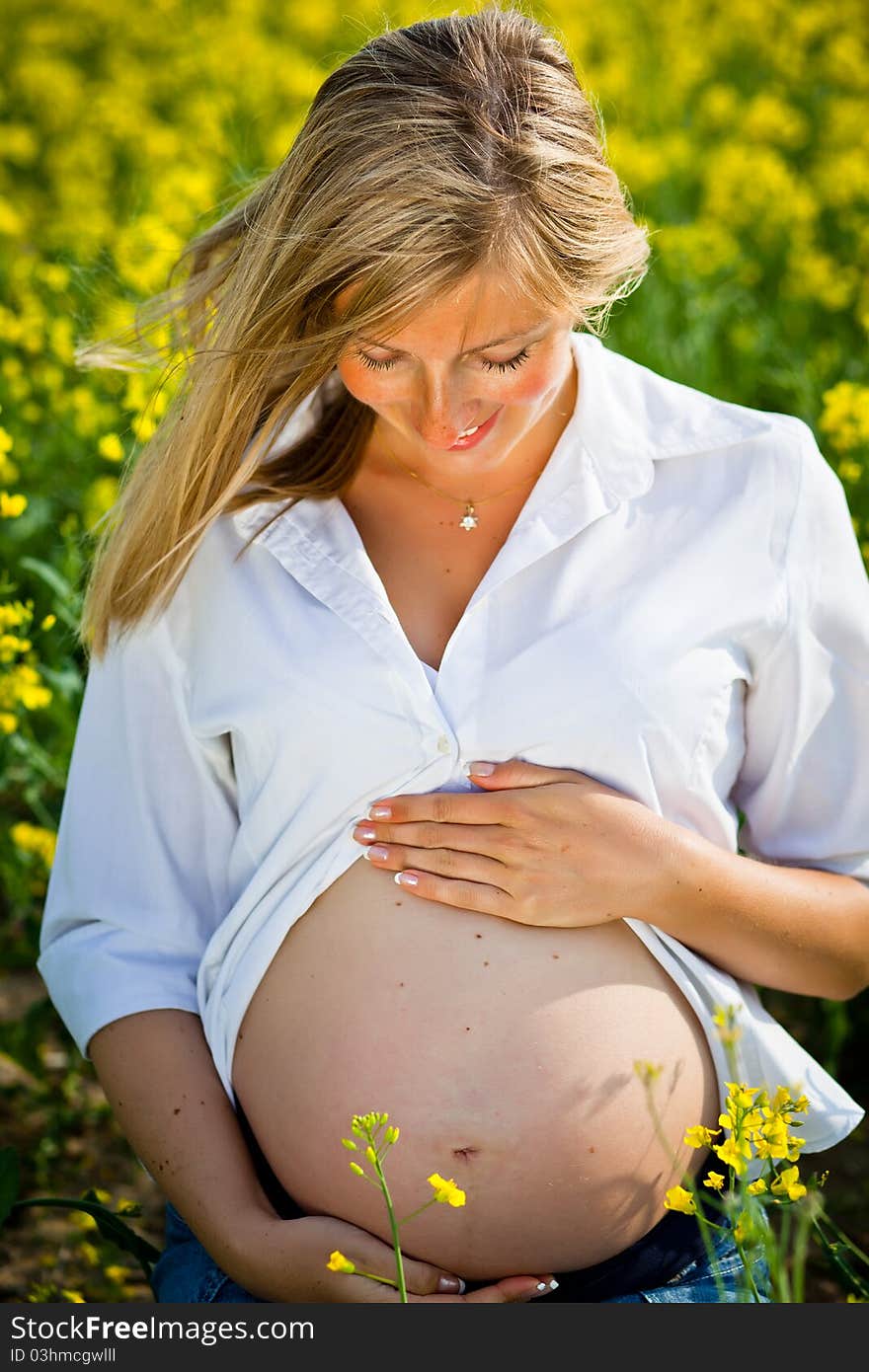 Pregnant woman sitting on green field