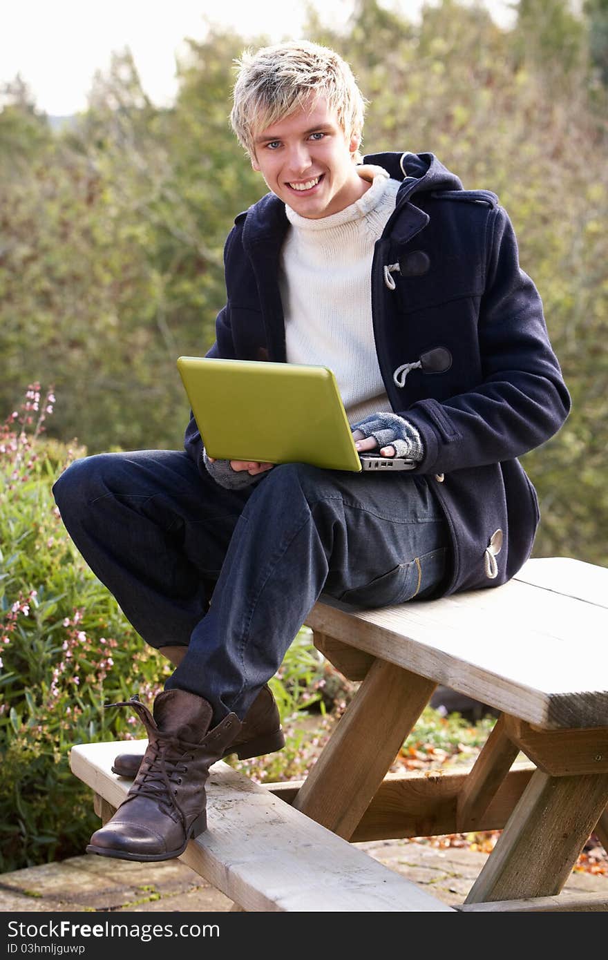 Young man with laptop computer smiling