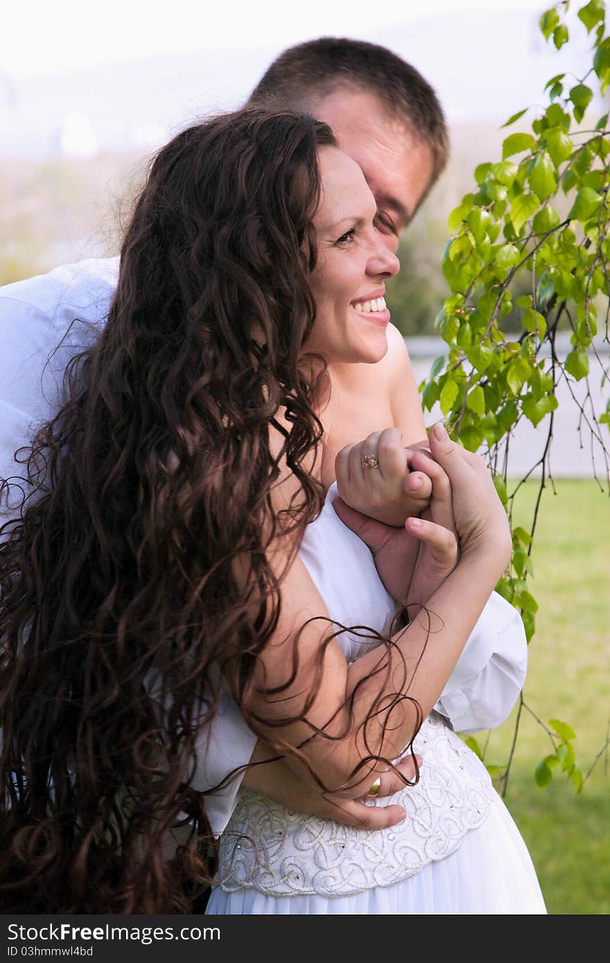 A couple on their wedding day kissing and laughing. A couple on their wedding day kissing and laughing