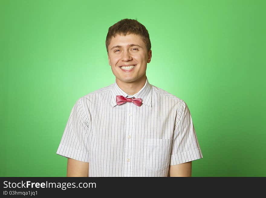 Handsome young man in a shirt with a green background smiling at the camera. Botanica. Handsome young man in a shirt with a green background smiling at the camera. Botanica