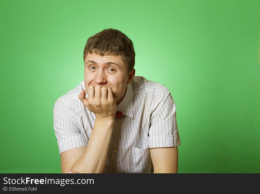 Handsome young man in a shirt with a green background sad at the camera. Handsome young man in a shirt with a green background sad at the camera.