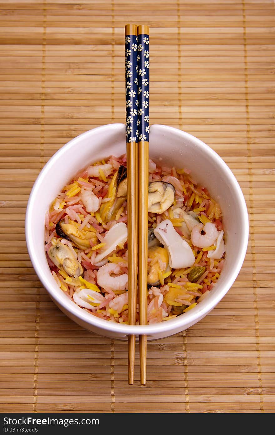 Fragrant rice and seafood in a bowl with chopsticks, ready to be eaten. Fragrant rice and seafood in a bowl with chopsticks, ready to be eaten.