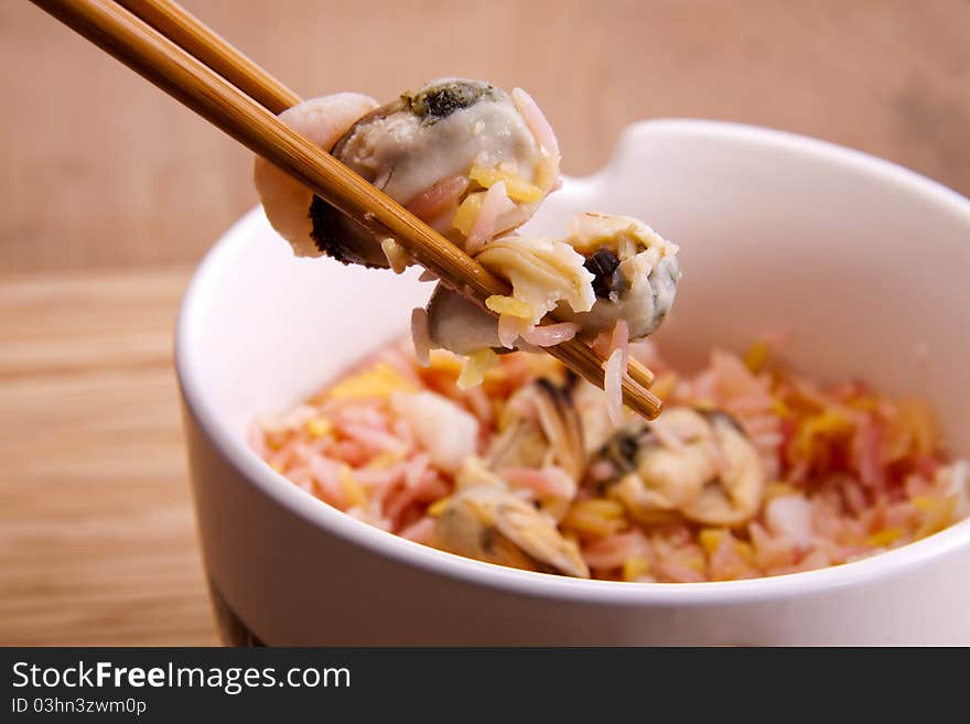 Fragrant rice and seafood in a bowl with chopsticks, ready to be eaten. Fragrant rice and seafood in a bowl with chopsticks, ready to be eaten.