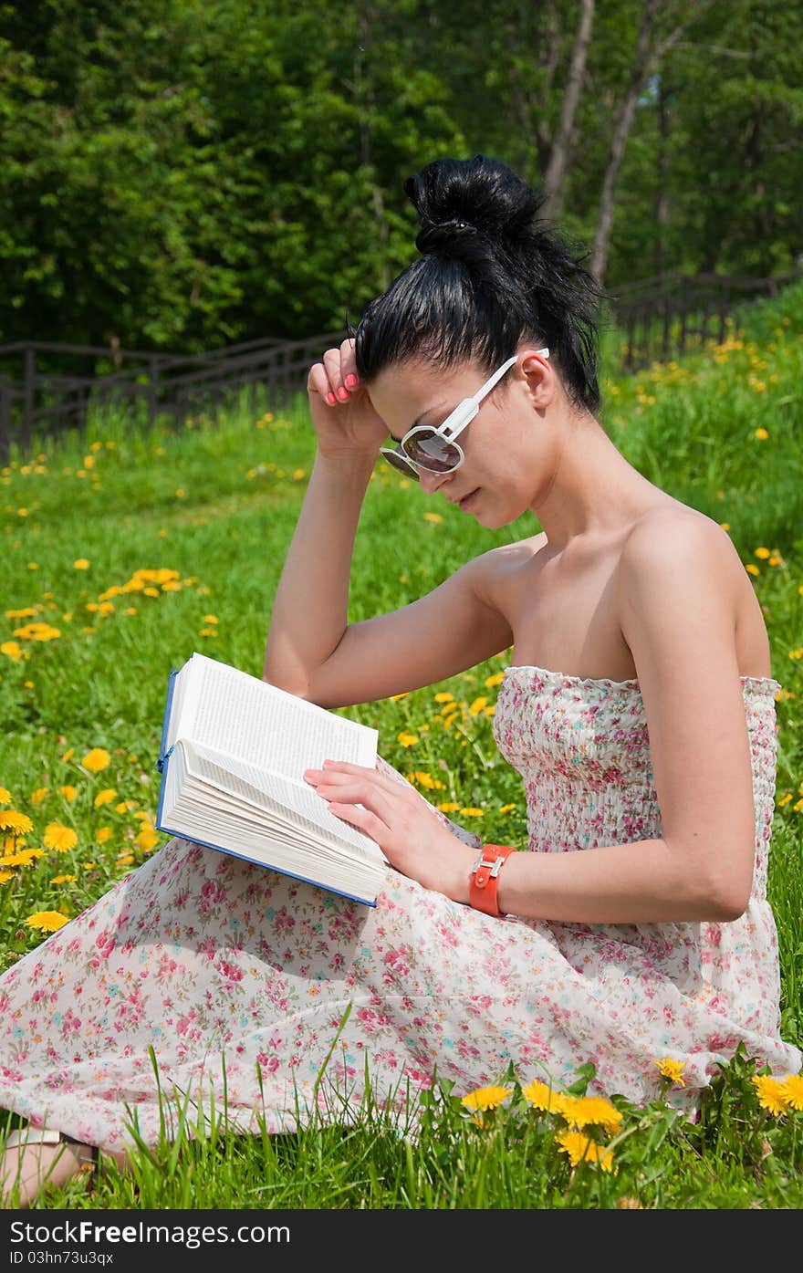 Young woman reading a book in the park