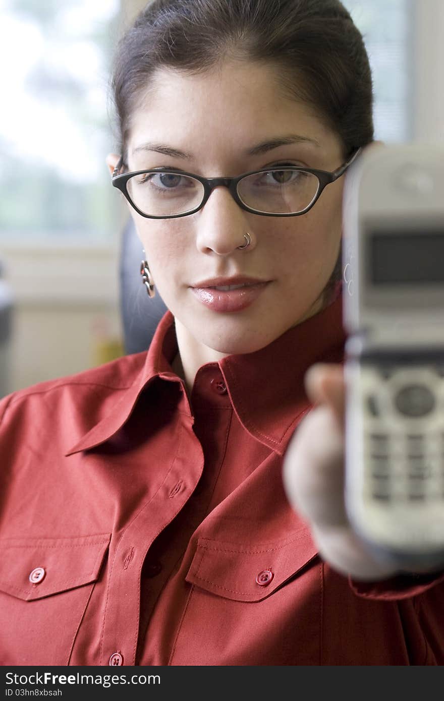 Young businesswoman holding cellphone with glasses