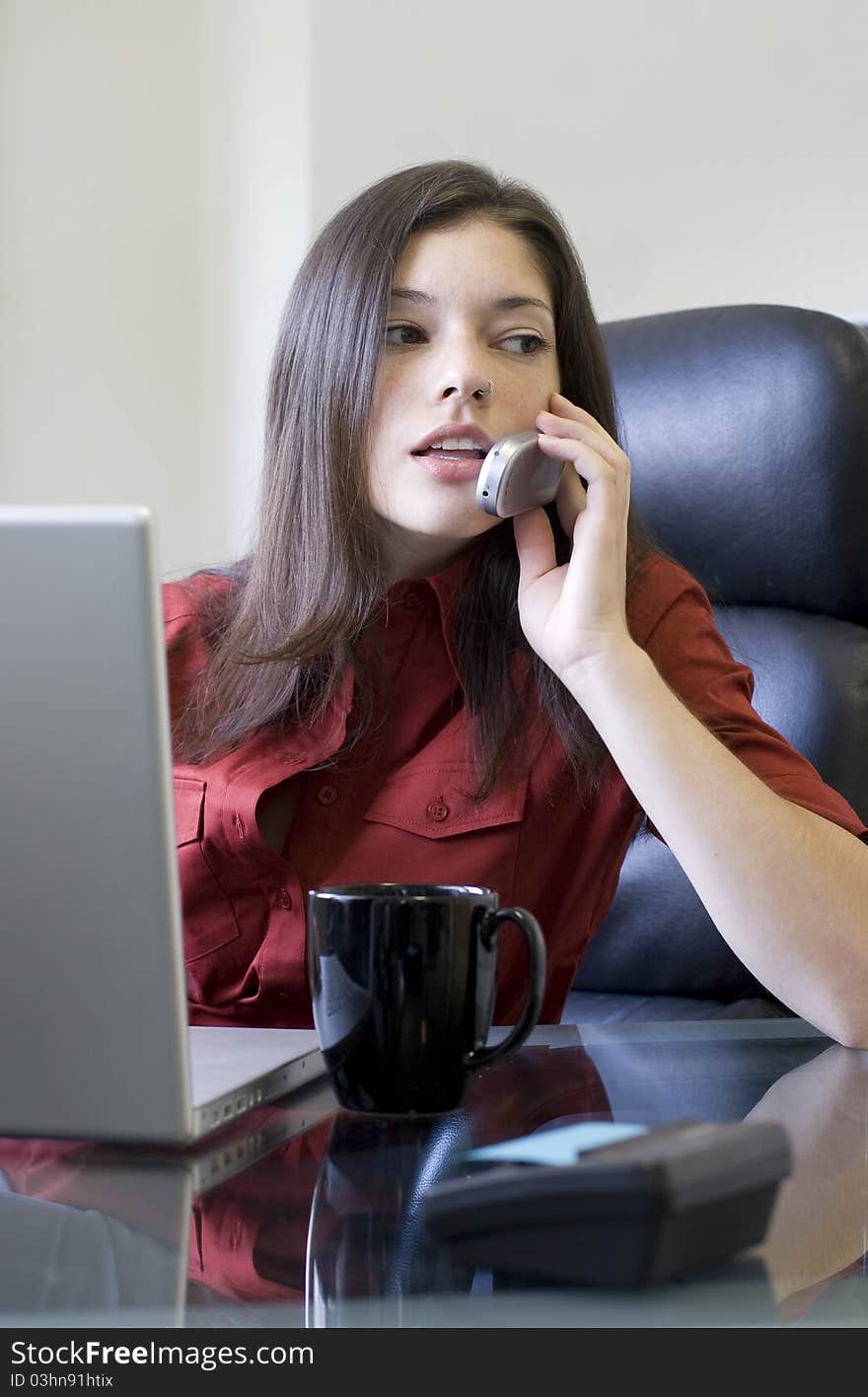 Young businesswoman with cellphone taking a call