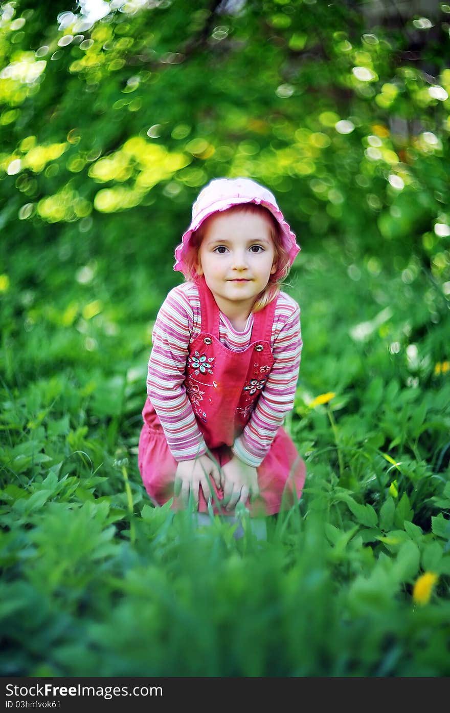 Playful little girl in hat on grass. may day