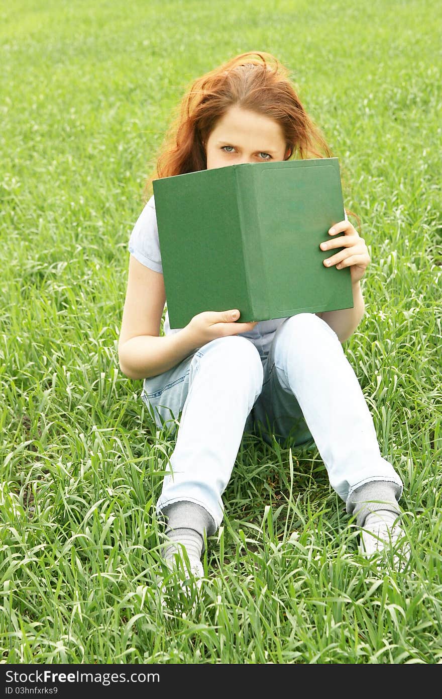 Girl on the grass with a book