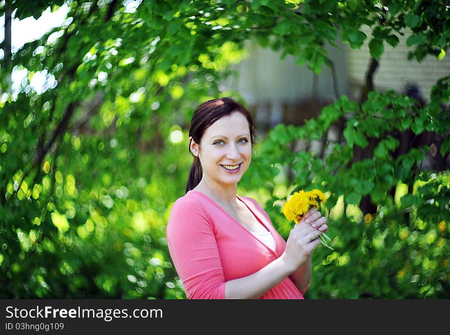 Future mom with bouquet of dandelions. spring day