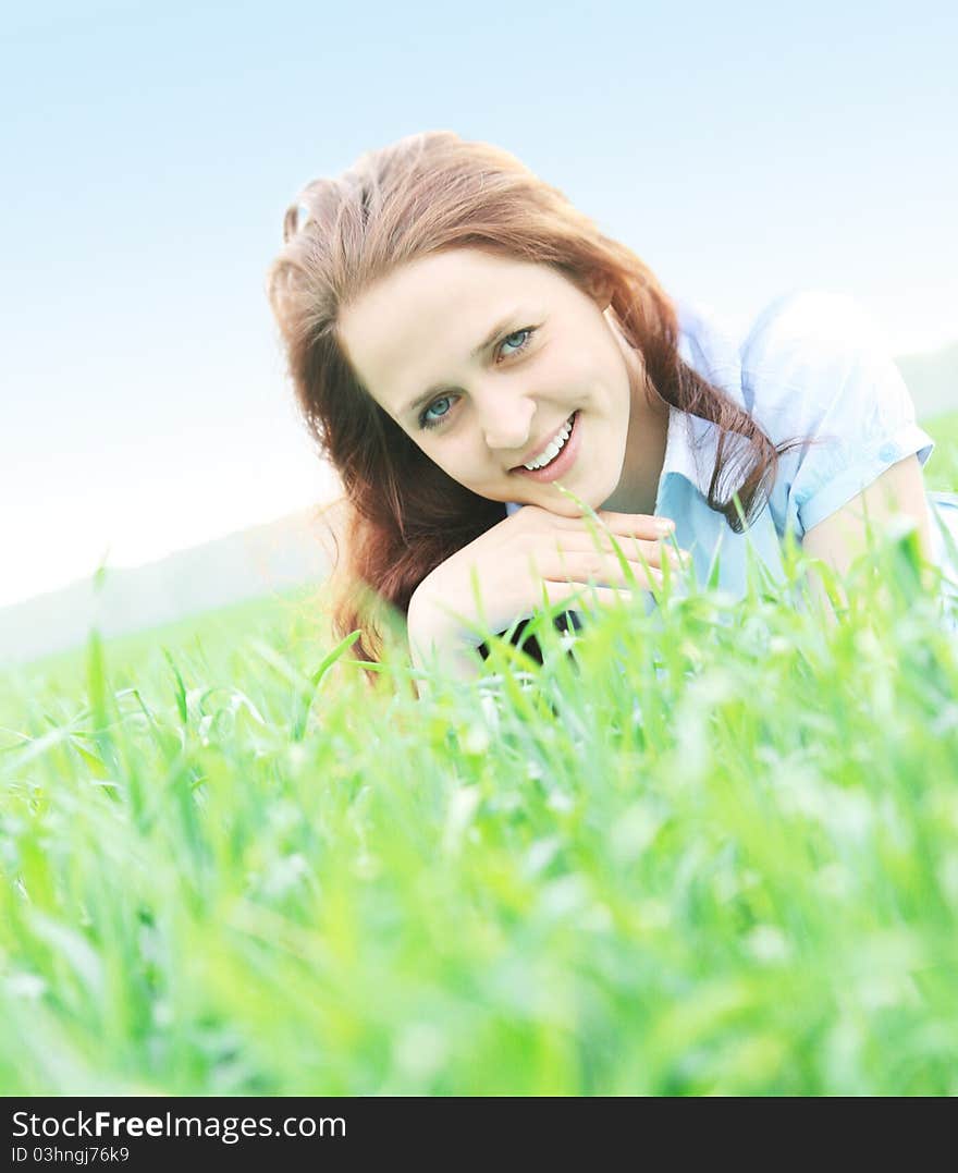 The girl lying on grass and smiles