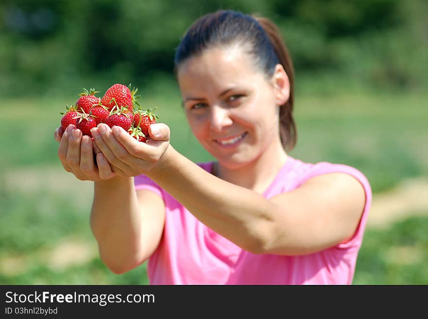 Fresh picked strawberries held by a pretty girl