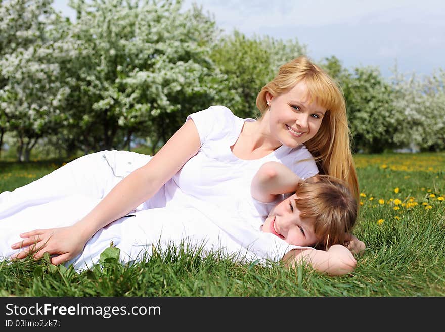 Happy girl and her mother in the spring park among flowers. Happy girl and her mother in the spring park among flowers