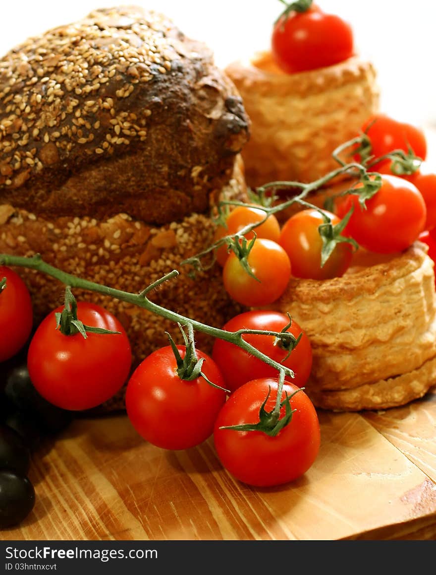 Tomatoes and bread on wooden board