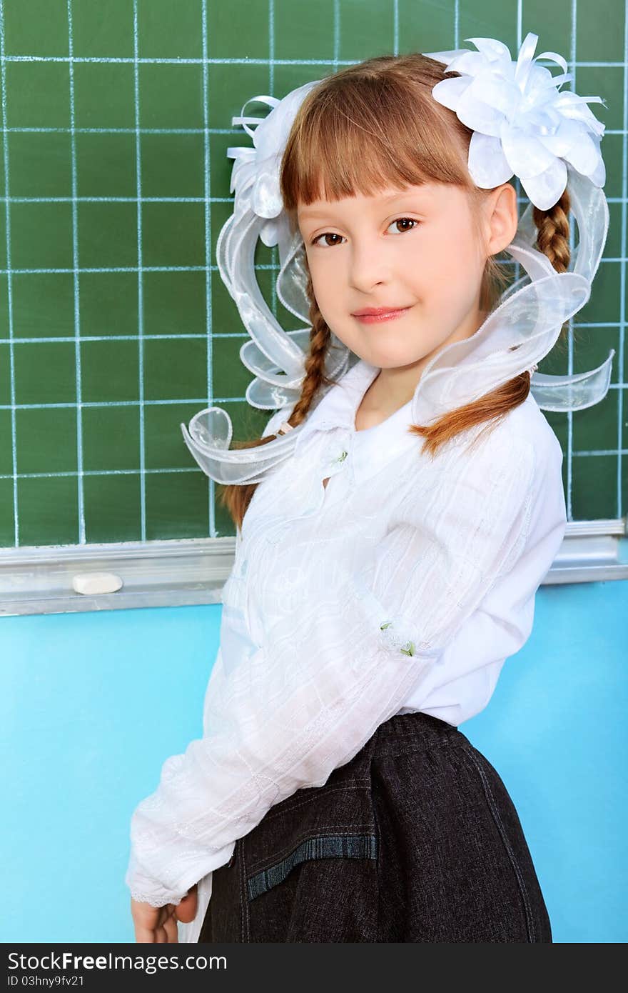 Portrait of a pretty schoolgirl in a classroom.