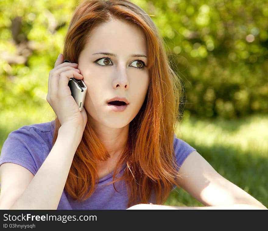 Surprised redhead girl with mobile phone