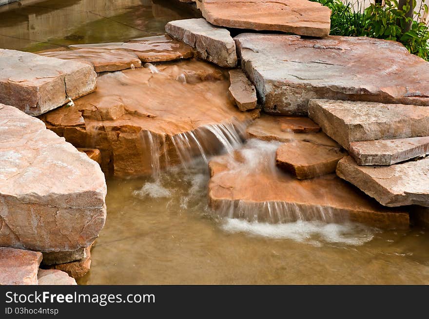 A waterfall with blurred water on red and brown rocks. A waterfall with blurred water on red and brown rocks