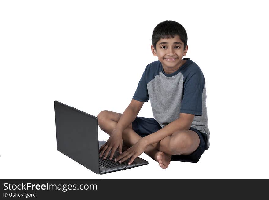 An handsome Indian kid having fun with laptop