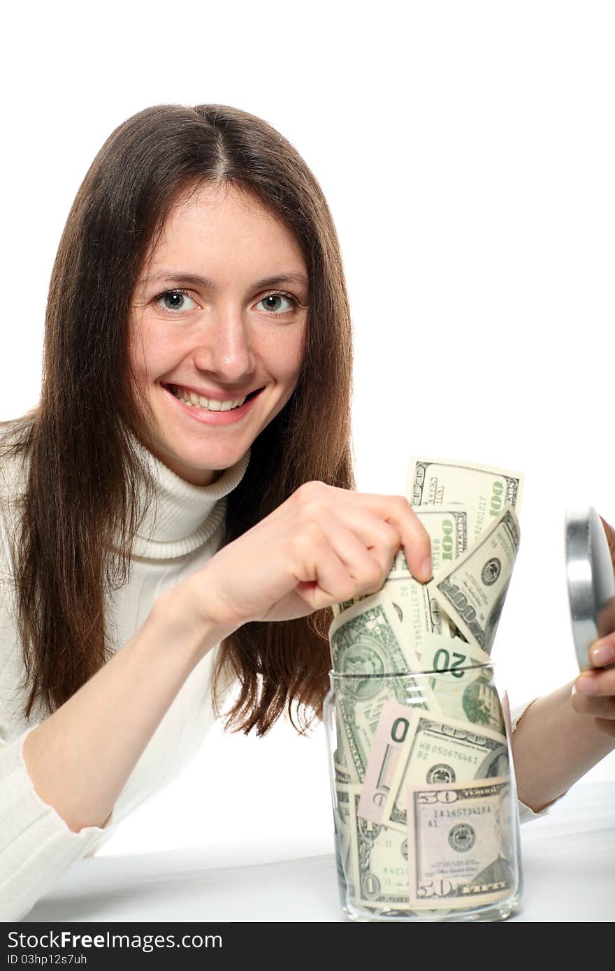 Young woman taking dollars from a jar