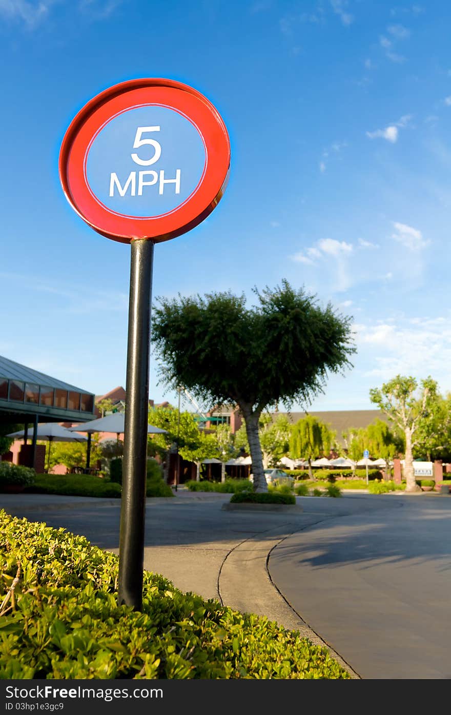 Five miles per hour sign against blue sky in shopping mall